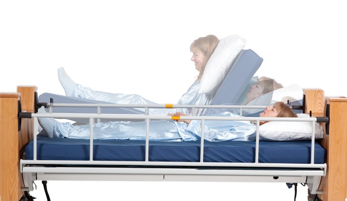 Freedom Bed by ProBed: a home lateral-rotation bed with a wooden headboard, white side rails, and a blue mattress.