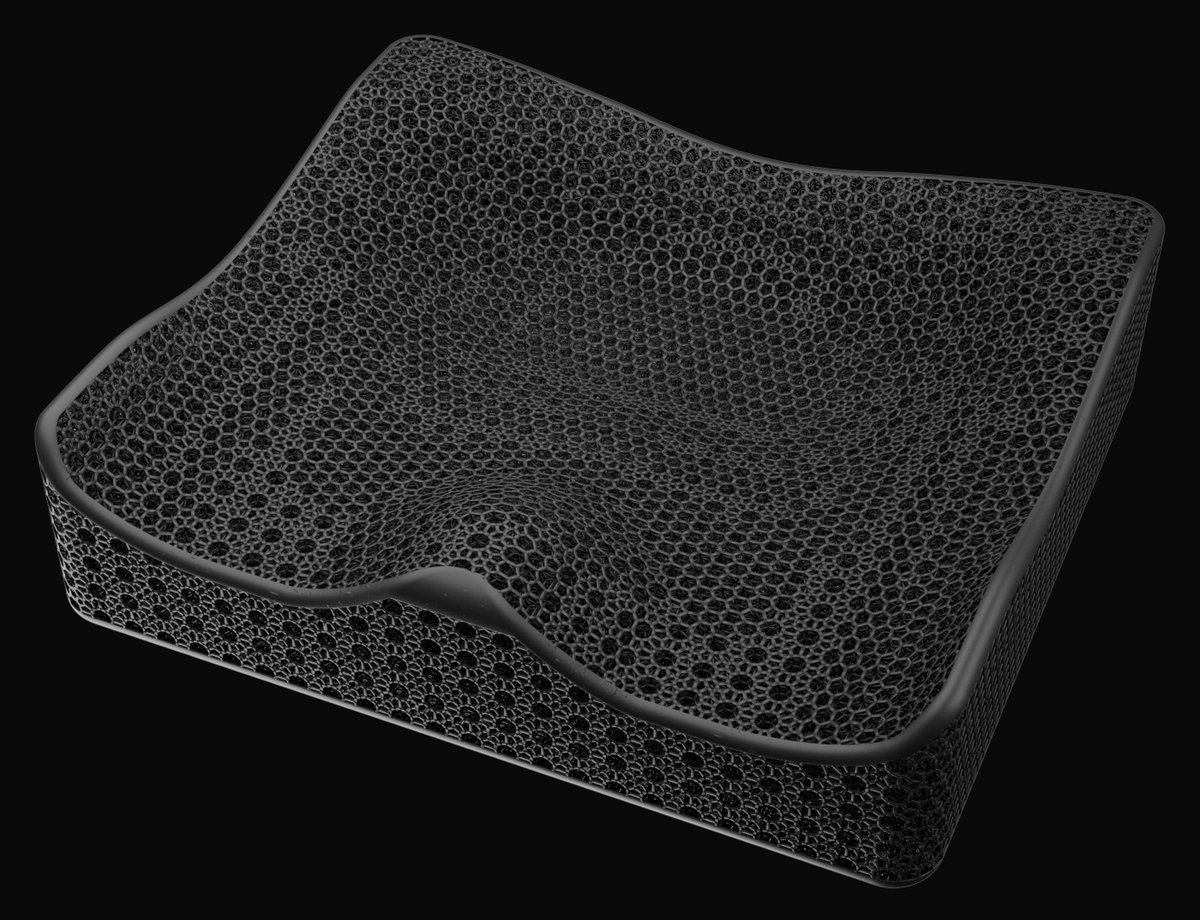 Kalogon Verro Lattice custom wheelchair cushion: a black 3D-printed open-lattice contoured seat cushion with a raised front pommel, shown empty against a dark background.